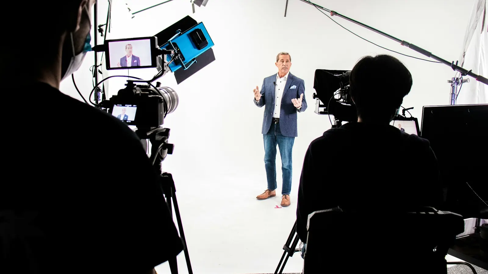 Ejecutivo grabando un video institucional en un set profesional, con cámaras y luces alrededor